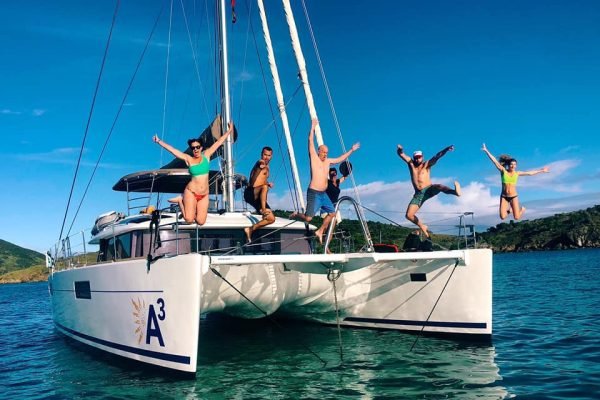 Guests jumping into the water from their yacht rental.