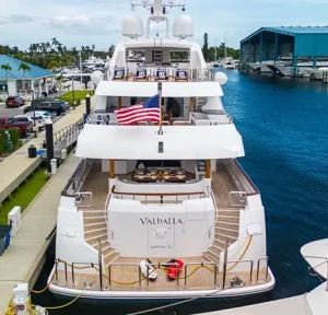 Stern view of Valhalla yacht docked at a marina, showcasing spacious decks and grand staircases.