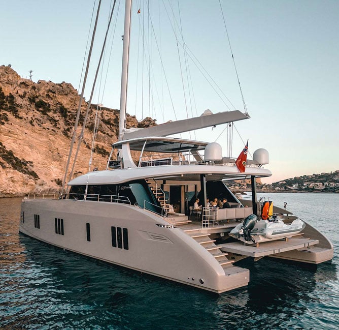 Viva La Vida Sunreef 80 catamaran at anchor, with an open aft deck and alfresco dining setup.